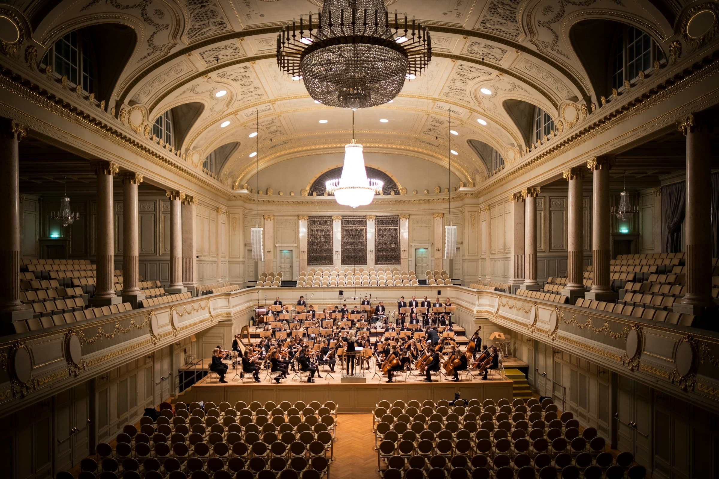 Orkester på scenen i en utsmykket konsertsal